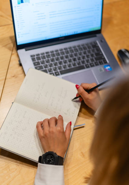istock Young woman writes text in paper notebook according to document 1820747534