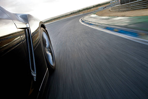 Black car in motion on a speed track. Low angle view.