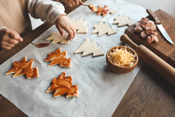 istock Child making pizza in the shape of a Christmas tree, activity idea 1820750793