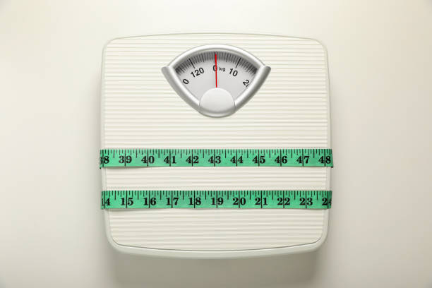 istock Scales tied with measuring tape on white background, top view 1820754610