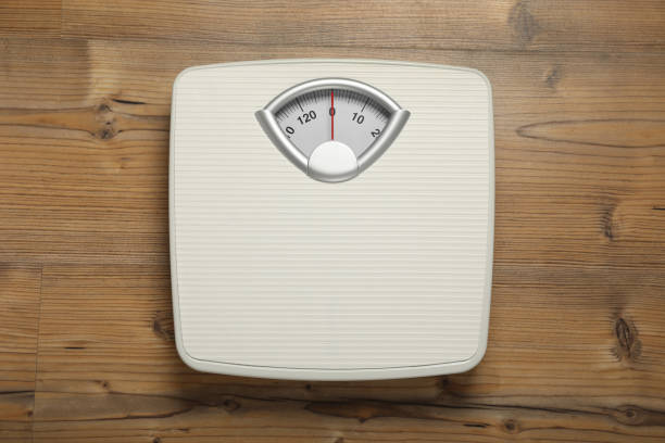 istock Mechanical scales on wooden floor, top view 1820754634