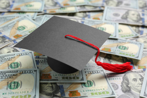 istock Scholarship concept. Graduation cap on banknotes, closeup 1820759538