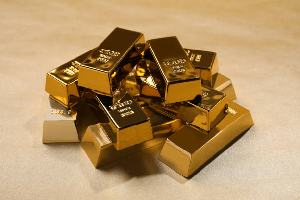 istock Many shiny gold bars on color background 1820759543