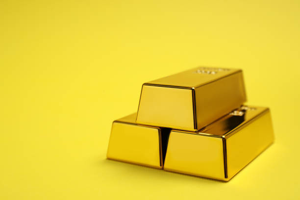 istock Stack of shiny gold bars on yellow background. Space for text 1820762314