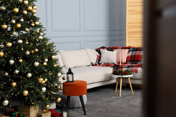 istock Beautiful Christmas tree, gift boxes and sofa in living room 1820771585