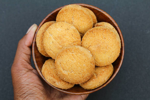 Holding some osmania biscuits in a wooden bowl
