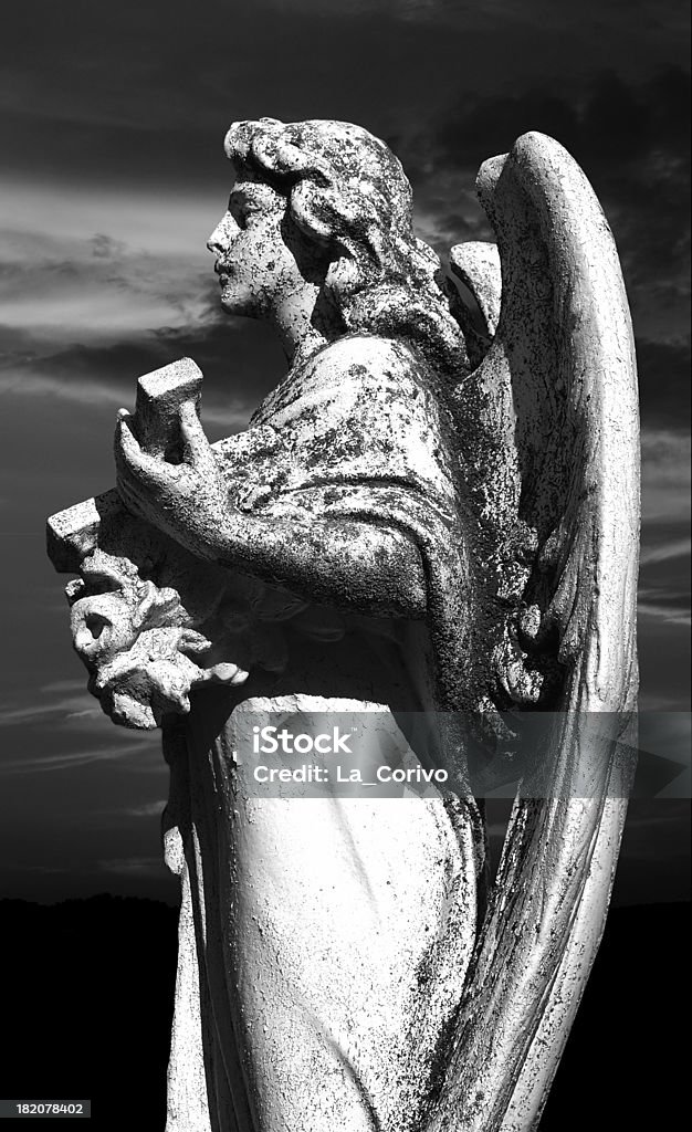 Statua di angelo su sfondo di cimitero al tramonto - Foto stock royalty-free di Angelo