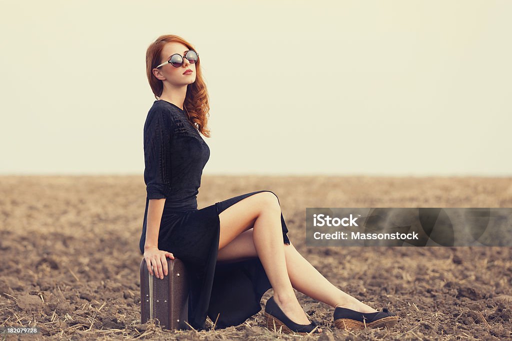 Fashion redhead women with suitcase at autumn field Adult Stock Photo
