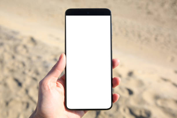 istock Man using weather forecast app on smartphone near sand outdoors, closeup 1820813040