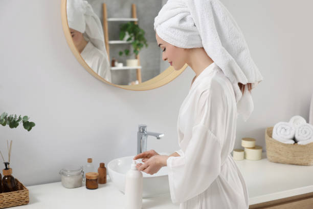 istock Beautiful young woman using body cream in bathroom, space for text 1820815798