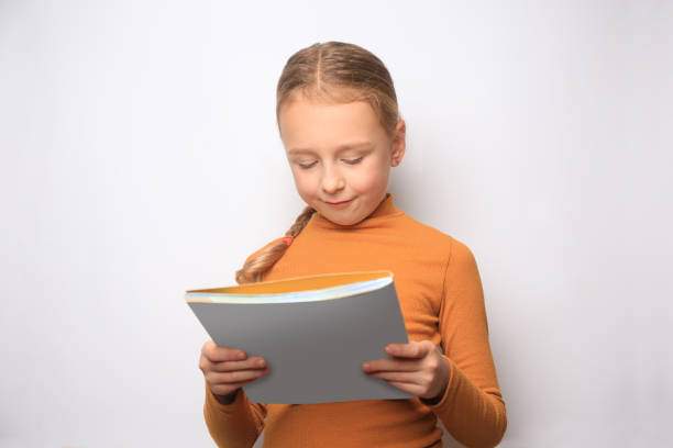 istock Little girl reading book on white background 1820816402