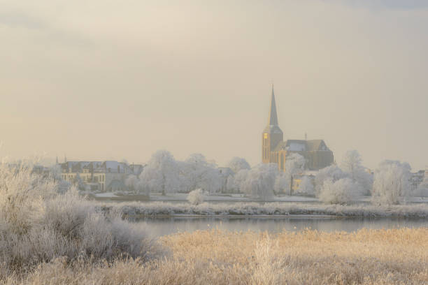 View on Kampen and river IJssel in winter in Holland. Kampen is an ancient Hanseatic League in Overijssel, The Netherlands. The Bovenkerk is visible in the foreground of the city.