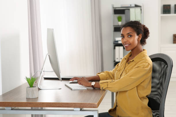 istock Smiling African American intern working with computer at table in office 1820831019