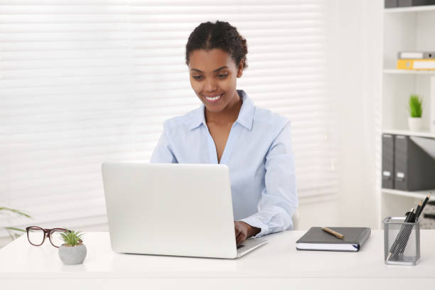 istock Smiling African American intern working on laptop at white table in office 1820831042