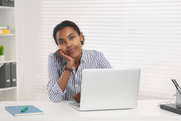 istock Sad African American intern working on laptop at white table in office. First work day 1820832139
