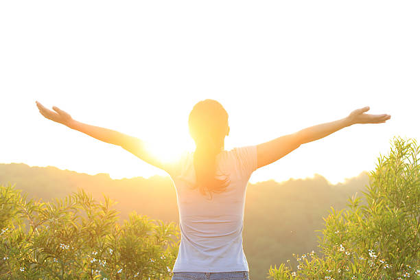 istock woman raised arms to sunrise 182083372