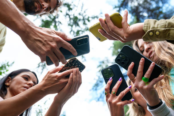 grupo de amigos compartilhando conteúdo com smartphones ao ar livre - memphis tennessee audio - fotografias e filmes do acervo