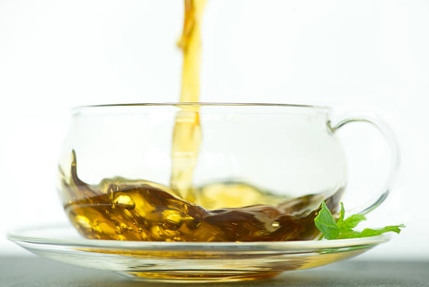 istock tea being poured into a glass teacup 182083439