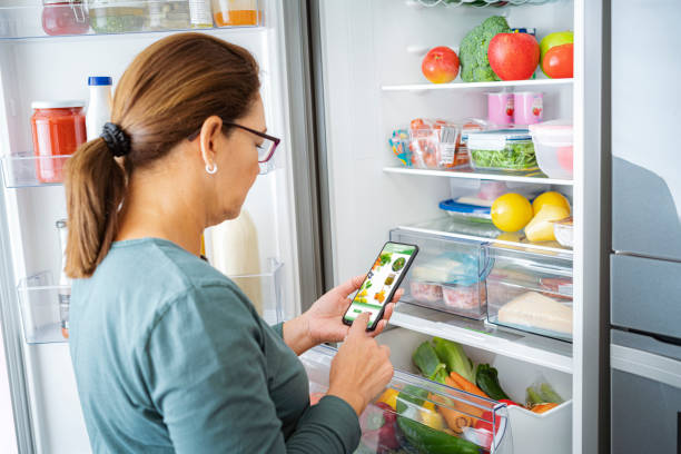 istock Woman ordering groceries online by the fridge 1820838100
