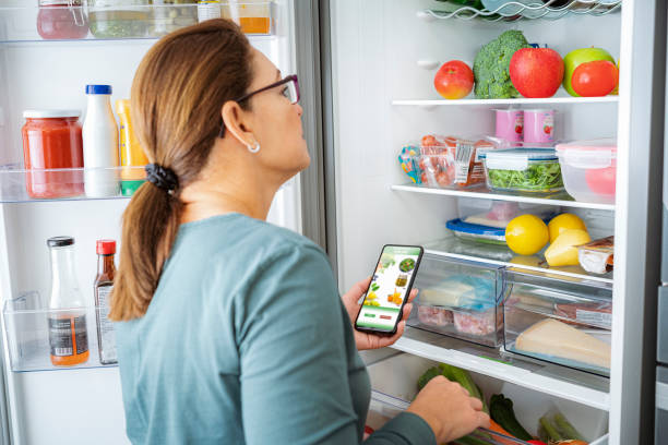 istock Woman opens the refrigerator while buying groceries online 1820838303