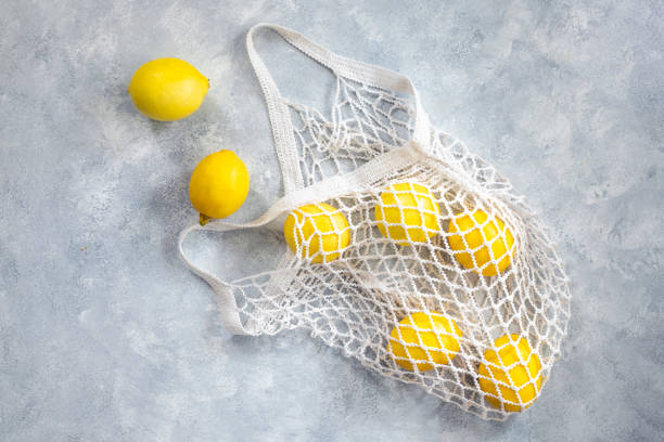 istock Mesh shopping bag with lemons. Modern reusable shopping, eco friendly lifestyle, zero waste concept.Top view. 1820863093