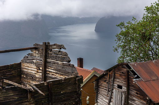 A view of Aurlandsfjord in Norway with abandoned farm buildings in the foreground