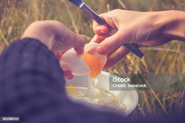 Mulher Fissuras Um Óvulo Na Rádio Fogão De Acampamento - Fotografias de stock e mais imagens de Acampar