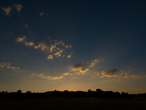 Dramatic sunrise or sunset behind silhouetted rocks