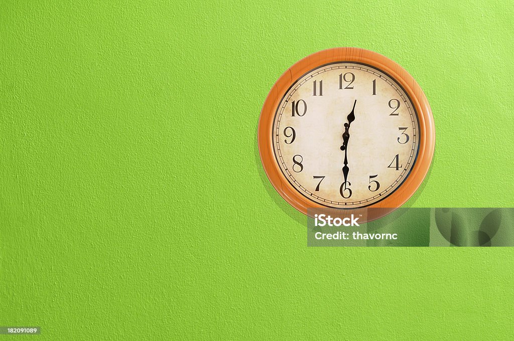 Clock showing 12:30 on a green wall 12 O'Clock Stock Photo