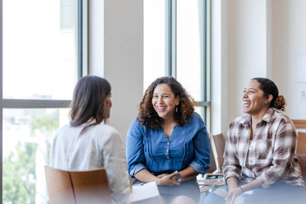 istock Mother and daughter laugh while chatting with unrecognizable counselor 1820921724