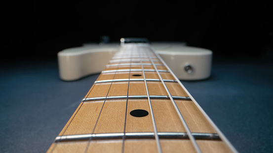 Macro of strings on electric guitar fretboard. Details of instrument close-up. Music, sound, art background. High quality