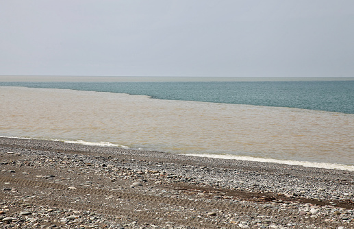 Empty seaside beach at evening in Fujian province, China. Wind turbines