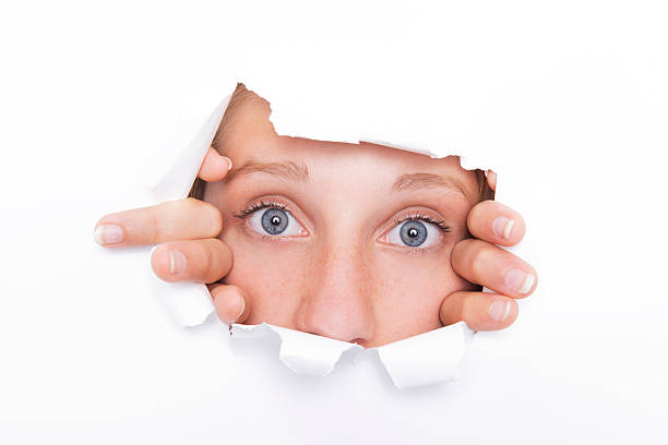 istock Young woman looks through a hole 182096342