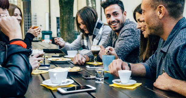 istock People tasting hot drinks at coffee restaurant - Millennial friends talking and having fun together at sidewalk cafe - Life style concept with happy men and women at bar cafeteria 1820964147