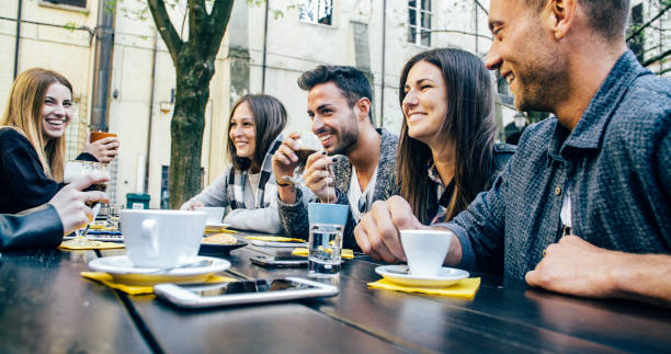 istock People tasting hot drinks at coffee restaurant - Millennial friends talking and having fun together at sidewalk cafe - Life style concept with happy men and women at bar cafeteria 1820964660