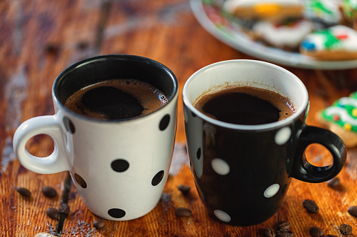 Two cups of hot coffee on the table in front of Christmas tree