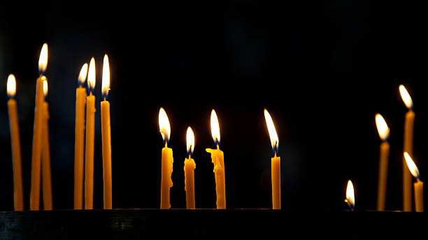 istock Several tall candles lit in a church 182099856