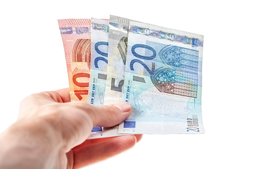 Man holding, giving out away a few Euro banknotes in hand, small bills, European currency simple concept One person, salary bonus, earning money and payment, paying with cash, tipping, bribing gesture