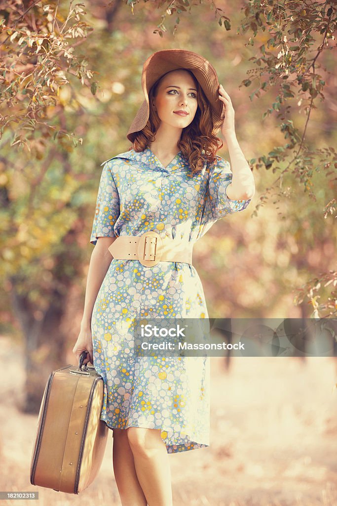 Redhead girl with suitcase at autumn alley Adult Stock Photo