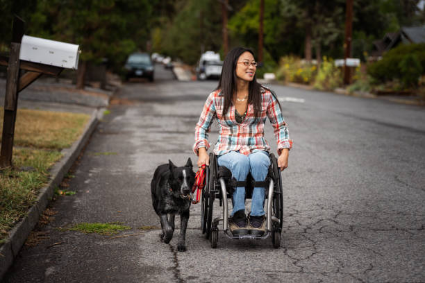 istock Active Asian woman using a wheelchair while taking her pet dog for a walk 1821029452