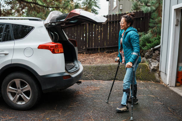 istock Woman with a disability using crutches and loading items into car trunk 1821029472