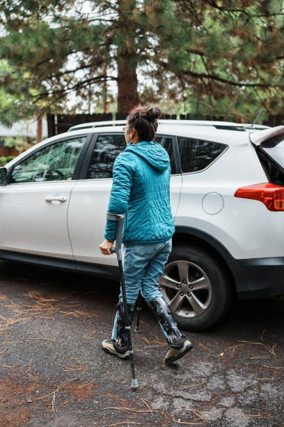 istock Woman using crutches walking toward car in driveway 1821029475