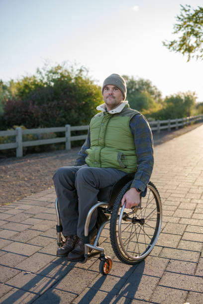 istock Man using wheelchair enjoying sunset on a cool, Autumn day 1821030599