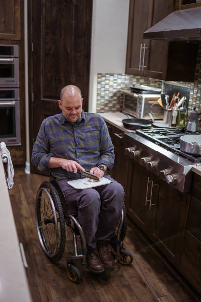 istock Man using a wheelchair and cooking at home 1821030620