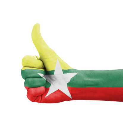 Hand with thumb up, Myanmar flag painted as symbol of excellence, achievement, good - isolated on white background