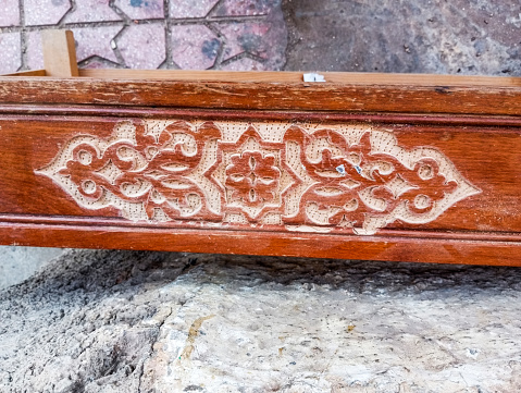An ancient wooden board with beautiful patterns. Weathered wood panel with curved islmaic pattern. Aged ornamented wood plate.
