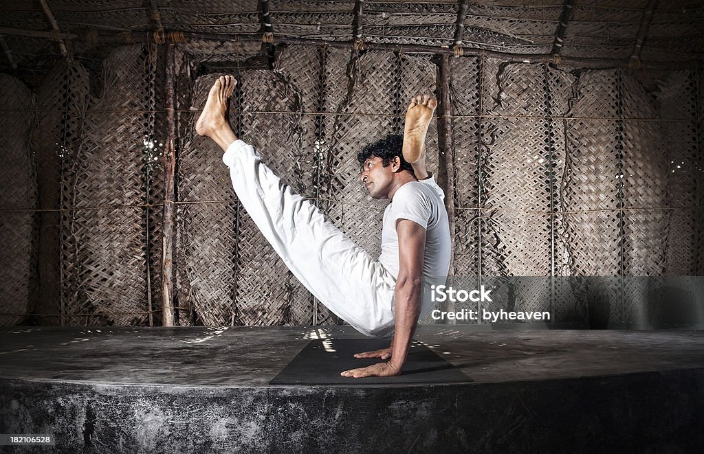 Advance Yoga pose Yoga chakorasana pose by Indian man in white cloth in yoga shala, Varkala, Kerala, India India Stock Photo