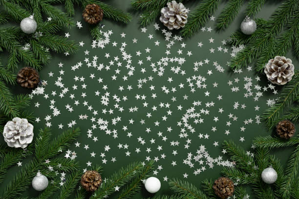 istock Christmas frame with fir branches, cones and silver decorations on green background. New Year greeting card with copy space. Top view, flat lay. 1821109175