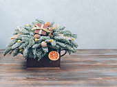 Christmas bouquet of fir branches, gifts and festive decorations on wooden background. Idea for a New Year gift. Copy space.