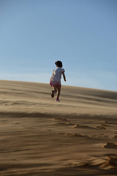 istock Young girl running in the desert 182111900